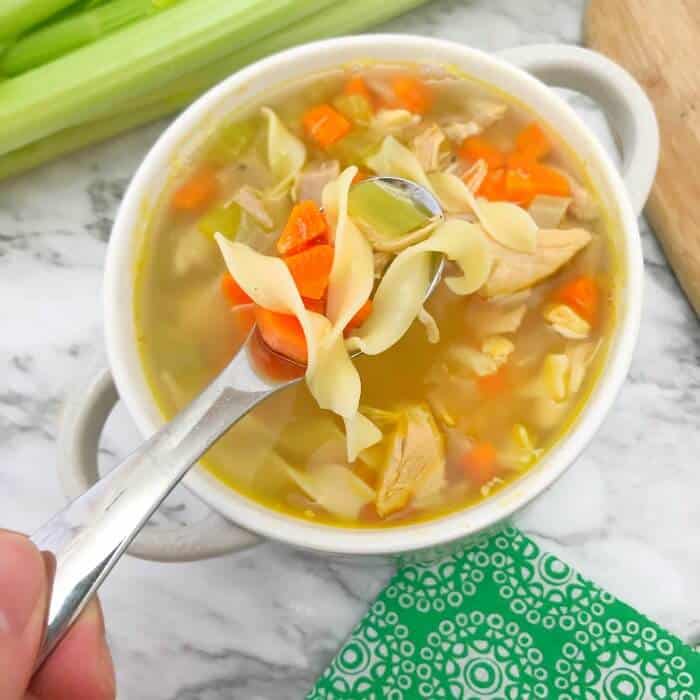 A bowl of chicken noodle soup from above