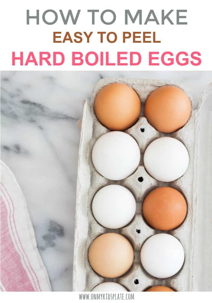 A dozen eggs of variosu shades of white and brown sit in an egg carton on a ktichen counter ready to become hard boiled eggs next to a dish towel.