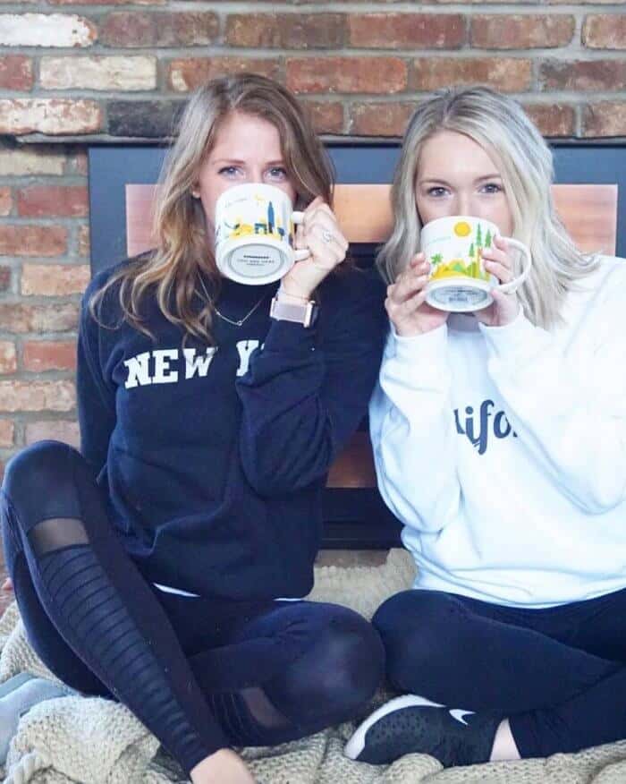 Emily and Tara from the blog "More Please Mama" holding coffee mugs.