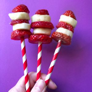 Banana and strawberry sliced on red striped sticks to look like Cat In The Hat Hats