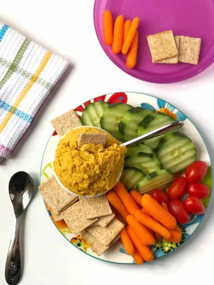 Close up of a platter of vegetable dip next to vegetables and crackers