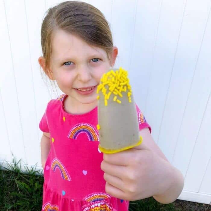 A little girl holding a popsicle