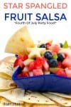 A heaping big bowl of fourth of July themed fruit salad in a star shaped bowl sits surrounded by hoemamde torilla chips. In the salsa we see watermelin, strawberries, blueberies and adorable pear bites and stars perfect for a potluck, BBQ or party.