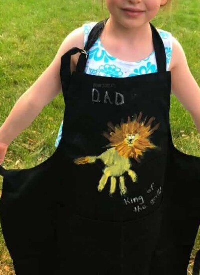 A child wearing an apron decorated like a lion