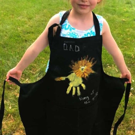 A child wearing an apron decorated like a lion