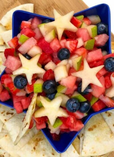 A star-shaped bowl full of fruit salsa with chips around the bowl
