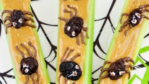 Three peanut Butter celery snack topped with raisins made to look like spiders