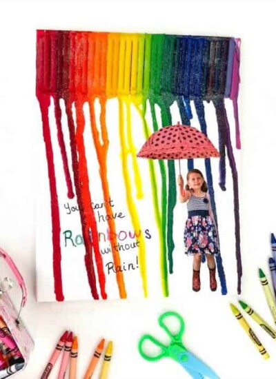 Child's melted crayon art melting over a picture of a child holding an unbrella