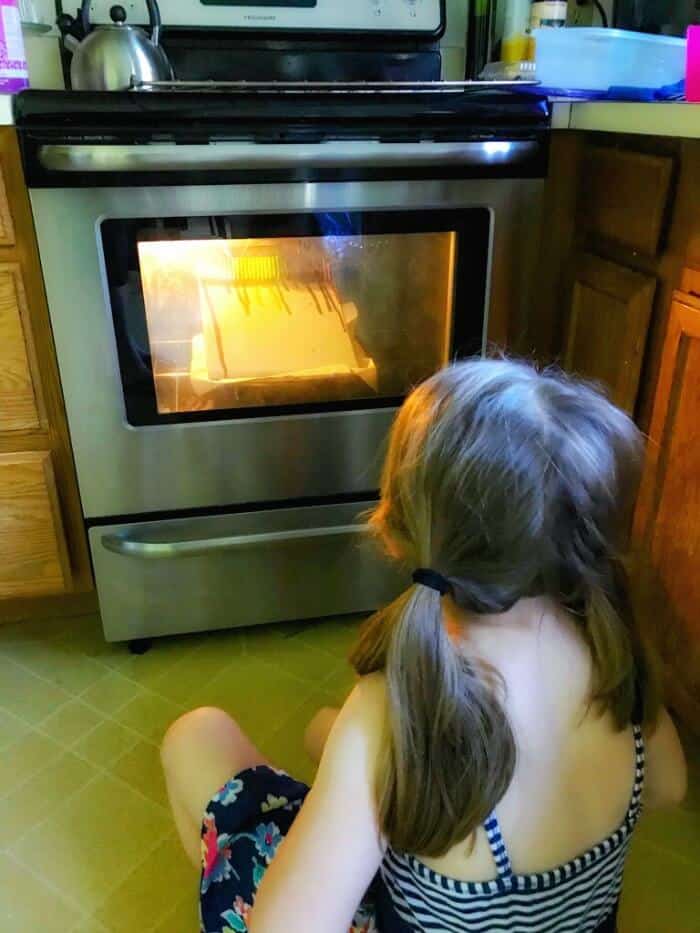 A child watching in front of an oven door