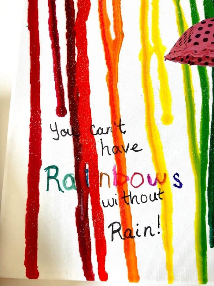 Canvas that says \"You can\'t have rainbows without rain with colorful melted crayon on top