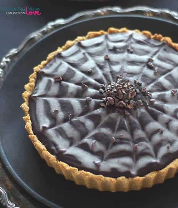 A Pumpkin chocolate tart decorated with a spiderweb decoration