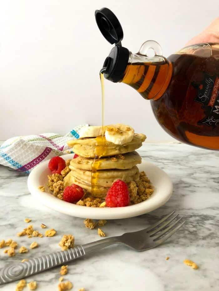 Syrup being poured on a stack of almond milk pancakes