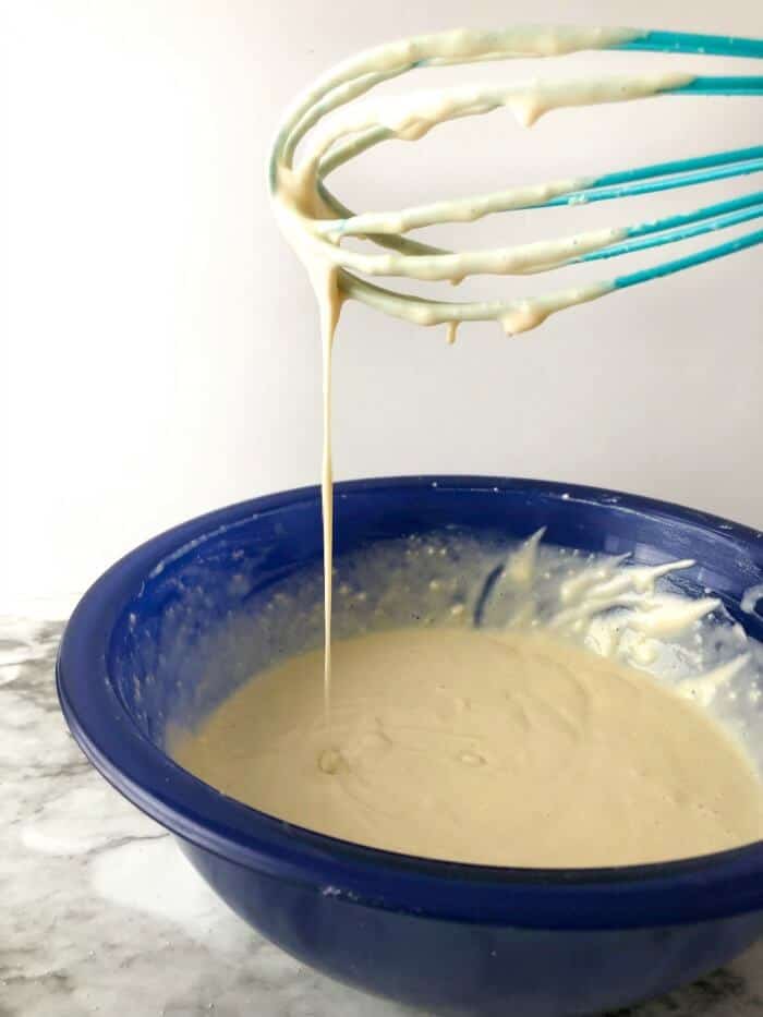 Bowl with batter for almond milk pancakes being mixed with a whisk
