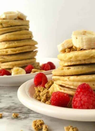 Two tall stacks of fluffy almond milk pancakes with fruit