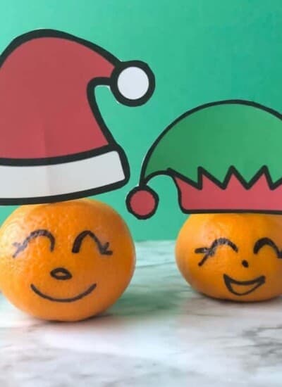 Clementines with faces drawn on the rinf and Santa and elf hats