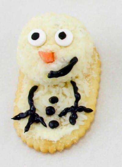 Cheese on a cracker close up decorated like  snowman