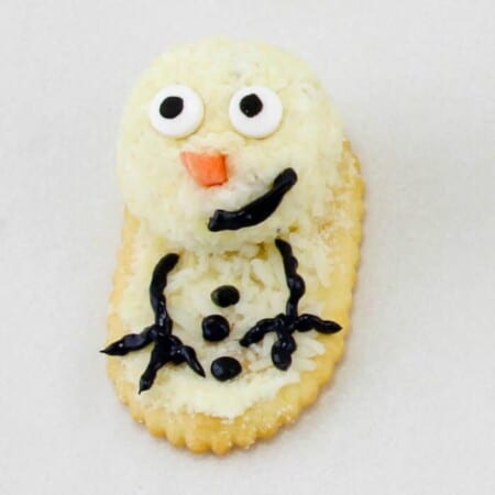 Cheese on a cracker close up decorated like  snowman