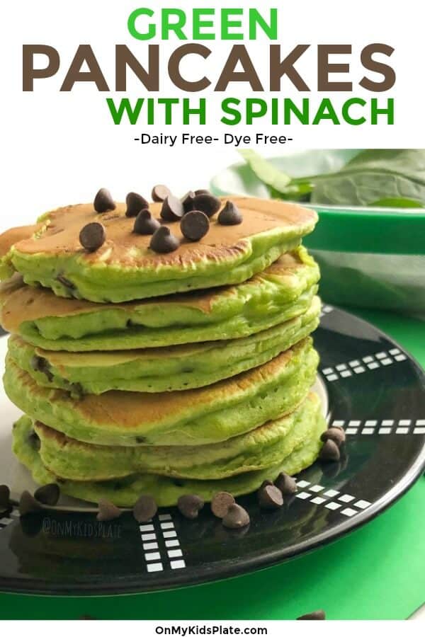 A stack of green pancakes topped with chocolate chips and fresh spinach in the background with text title overlay
