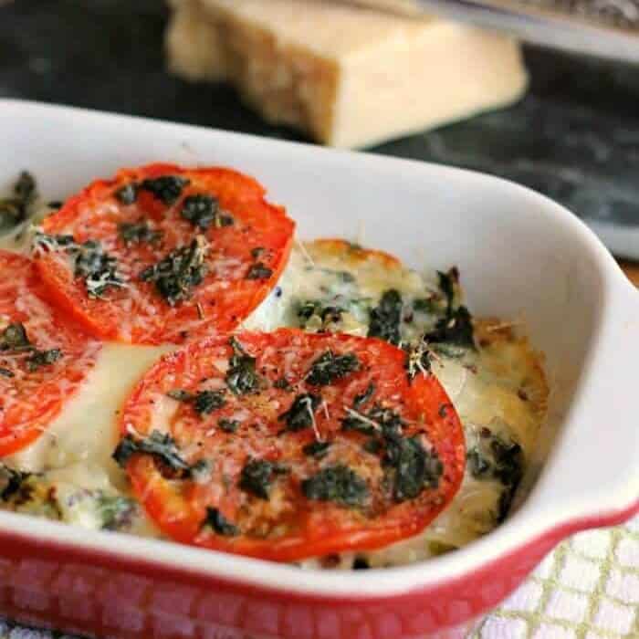 A casserole dish with cheese, tomatoes and basil cooked inside