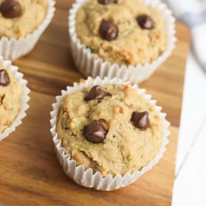 Several muffins with chocolate chips on a cutting board