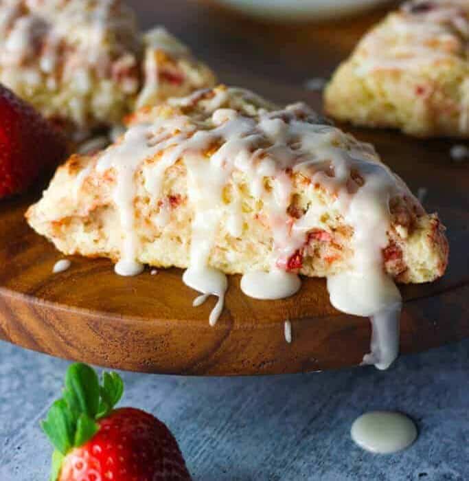 Strawberry Scone next to a strawberry on a cutting board
