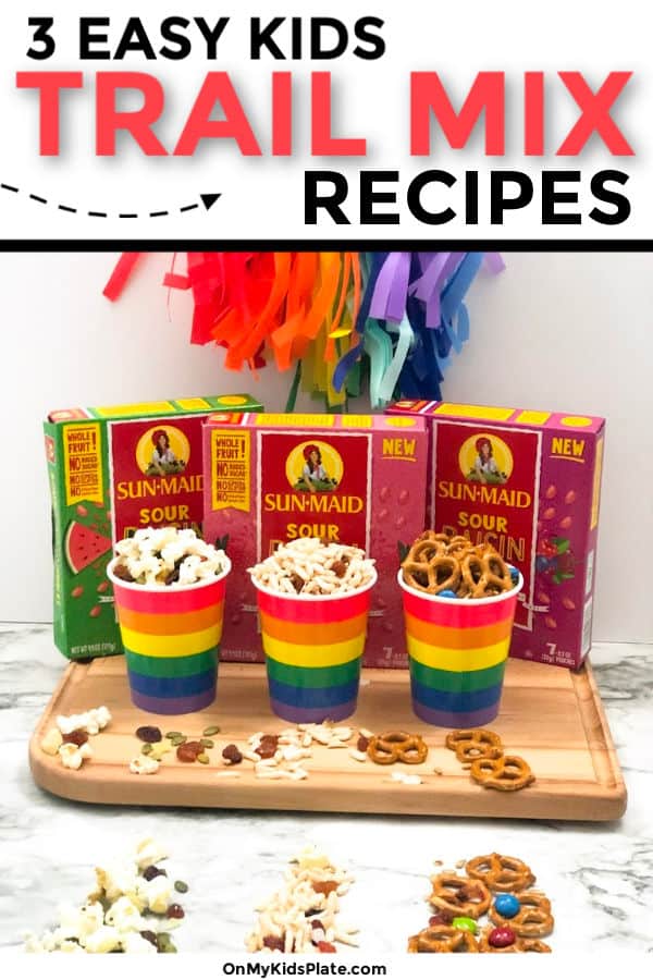Three different rainbow cups of different trail mixes on a cutting board next to three boxes of flavored raisins with text title overlay