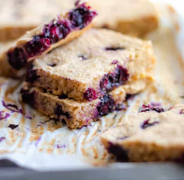 Breakfast bars stuffed with blueberries on parchment paper on a baking sheet