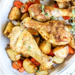 A close up plate of Chicken legs with carrots and potatoes