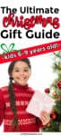 A little girl holding a present and standing next to a Christmas tree  with text title overlay