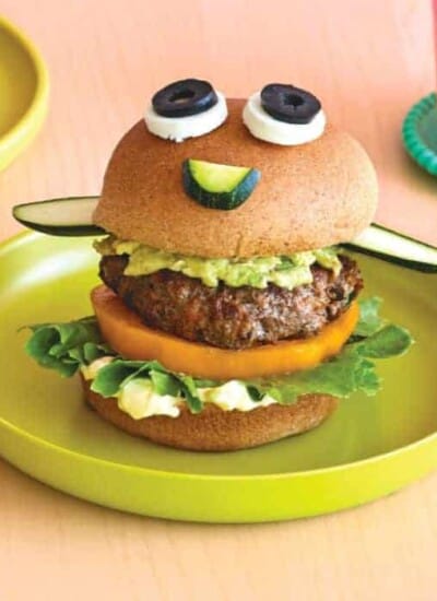 A beef burger made to look like a funny face on a plate