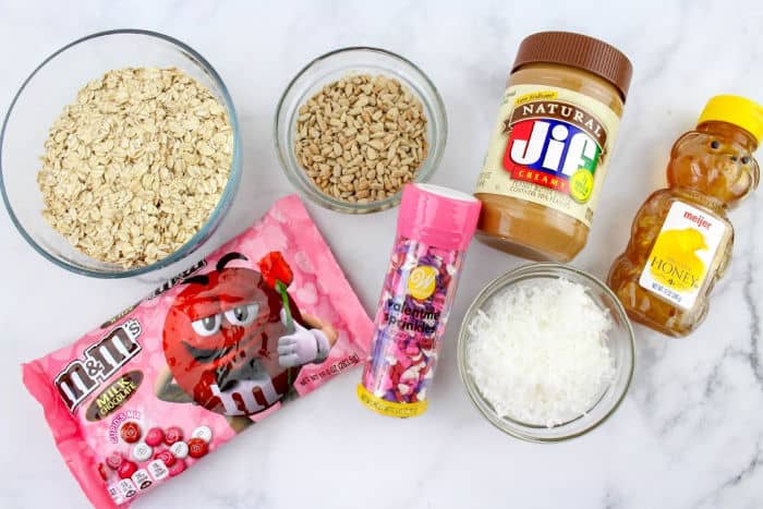 Jar of peanut butter, coconut, sprinkles, bag of chocolate candies, oats and honey from overhead