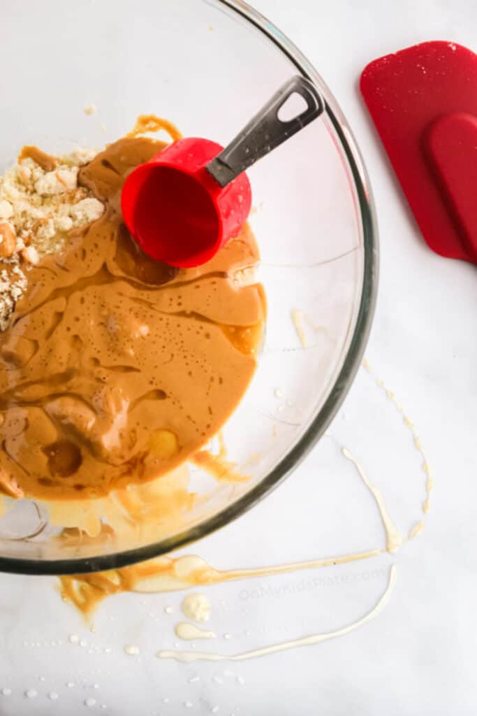 Mixing together oats, peanut butter and honey swirled in a bowl
