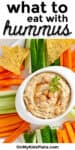 Hummus in a bowl on a platter with vegetables and chips