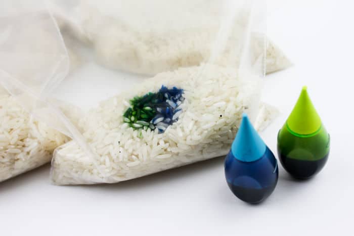 A bag of rice with food coloring inside and next to the bag