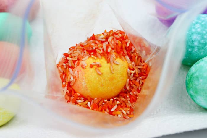 A look inside a bag full of orange rice and a orange Easter Egg