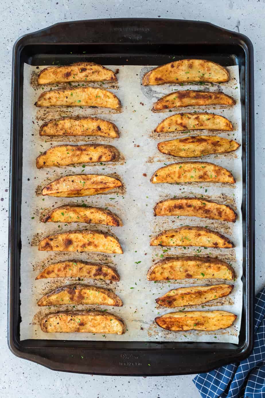 Crispy potato wedges on the pan evenly spaced after baking