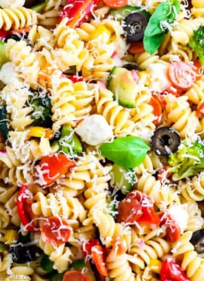 Close up view of pasta full of cheese, basil, pepperoni and olives for an italian pasta salad/