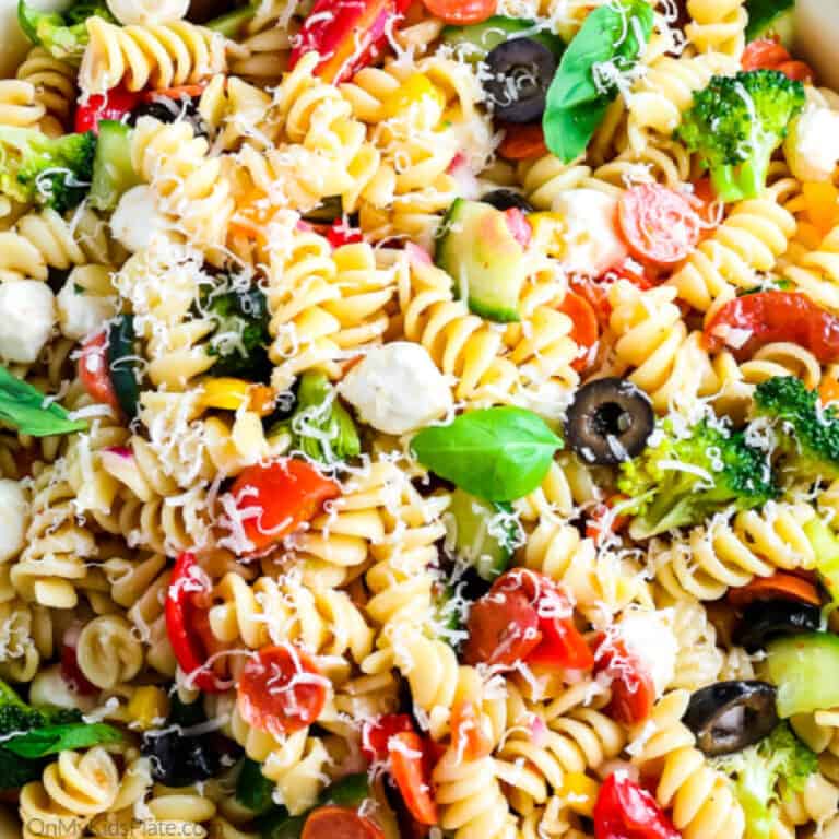 Close up view of pasta full of cheese, basil, pepperoni and olives for an italian pasta salad/