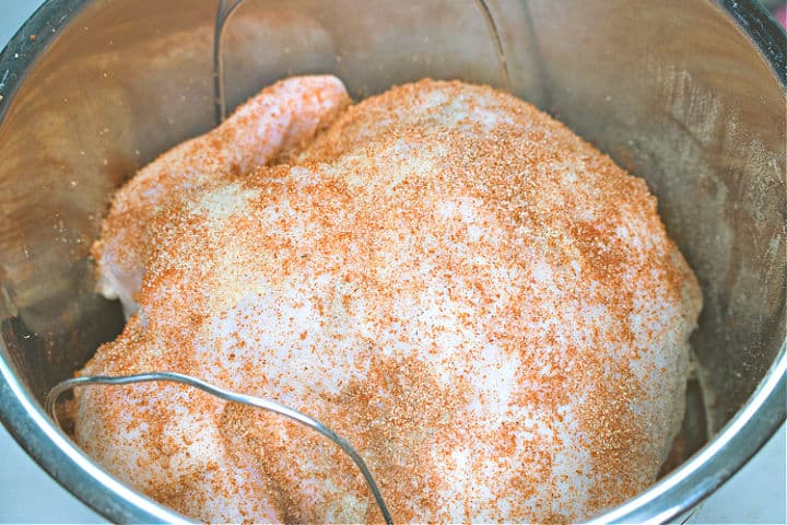 Whole raw chicken with spices inside an instant pot