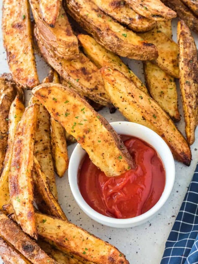 Grilled potato wedges with a dipping sauce.