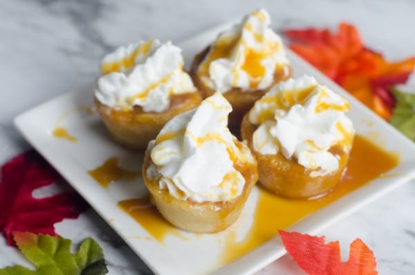Cookie bites filled with pumpkin and topped with caramel and whipped cream