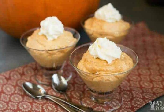 Orange mousse in three bowls with whipped cream
