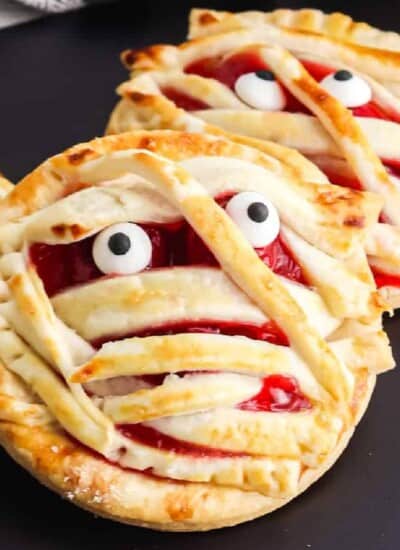 Close up of two cherry hand pies decorated like mummies