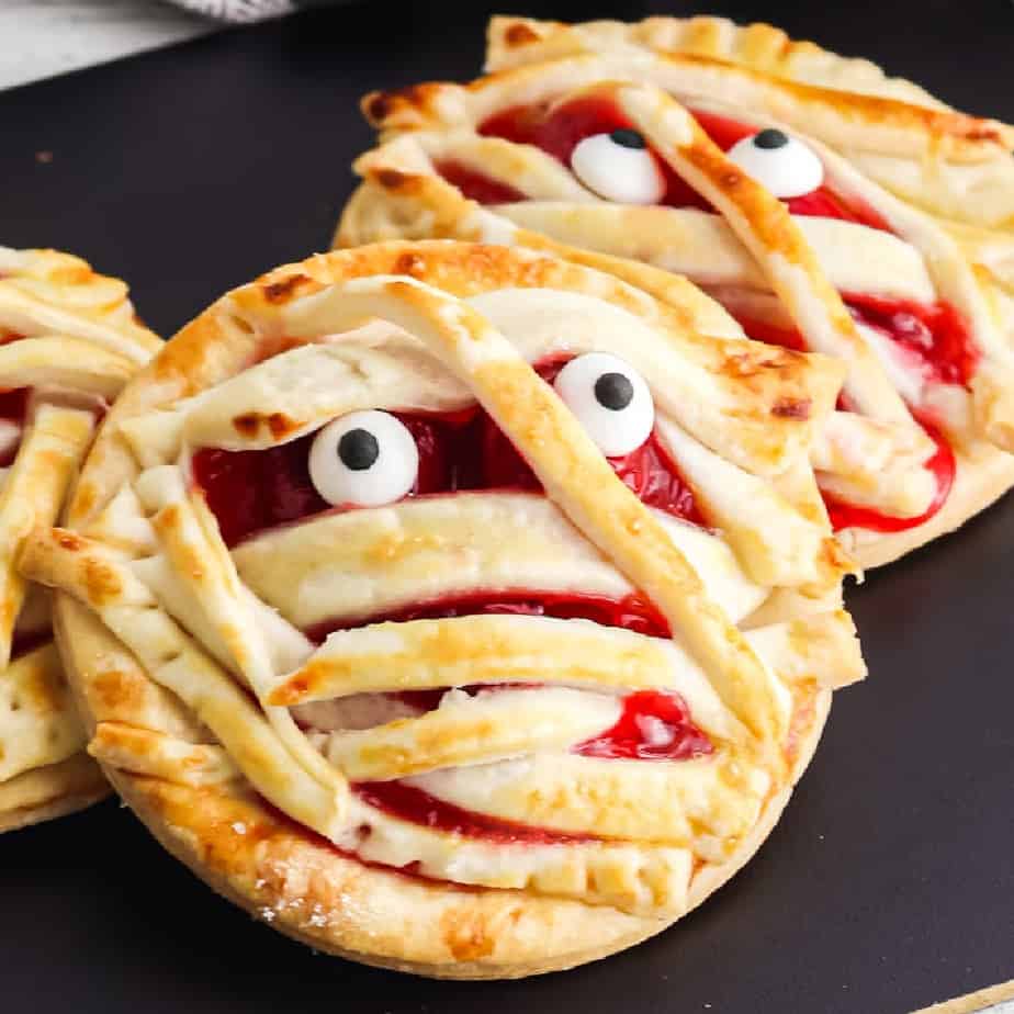 Close up of two cherry hand pies decorated like mummies