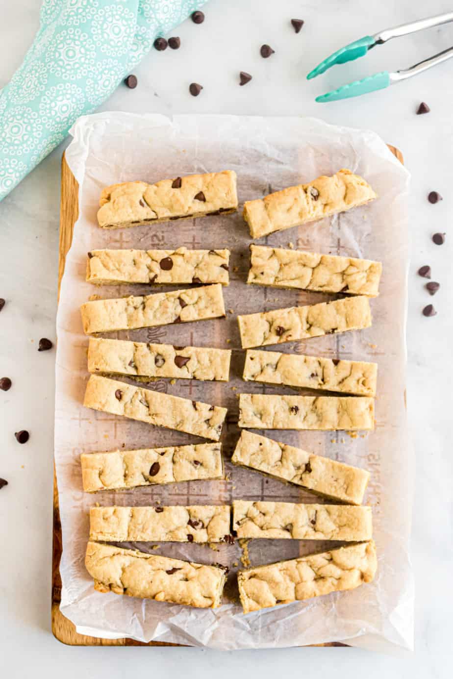 Chocolate chip cookie sticks cut into thin slices on a cutting board.