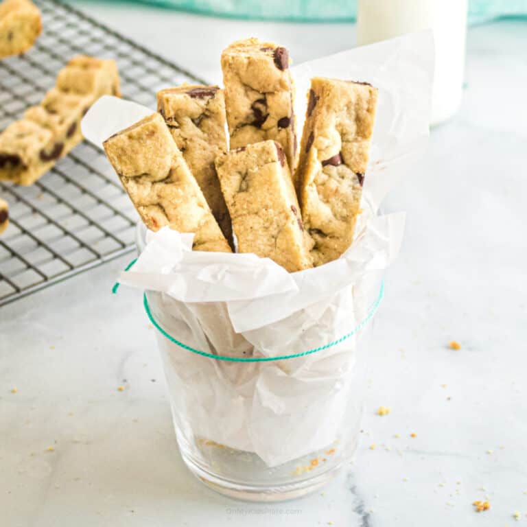 Chocolate cookie sticks served in a glass lined with parchment paper.