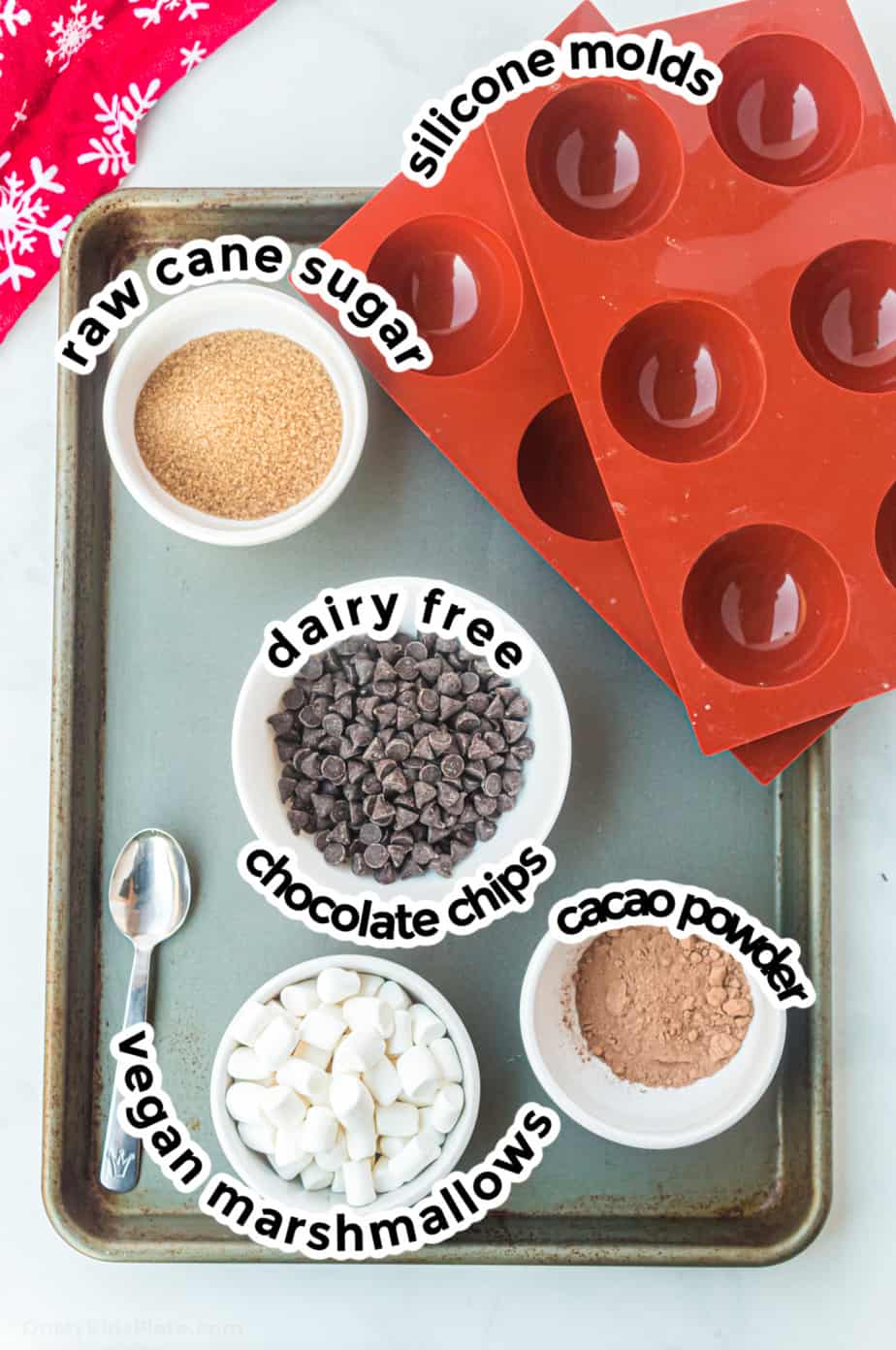 Ingredients for dairy free hot cocoa bombs on a baking sheet.