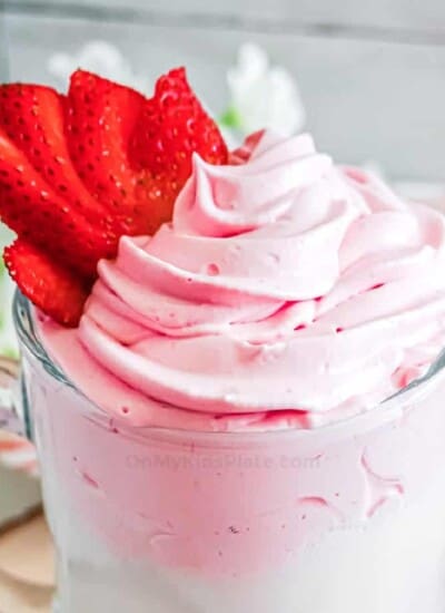 Close up of fluffy pink whipped strawberry milk in a glass