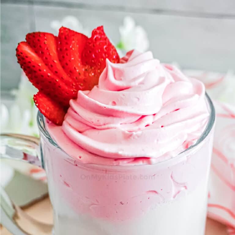 Close up of fluffy pink whipped strawberry milk in a glass