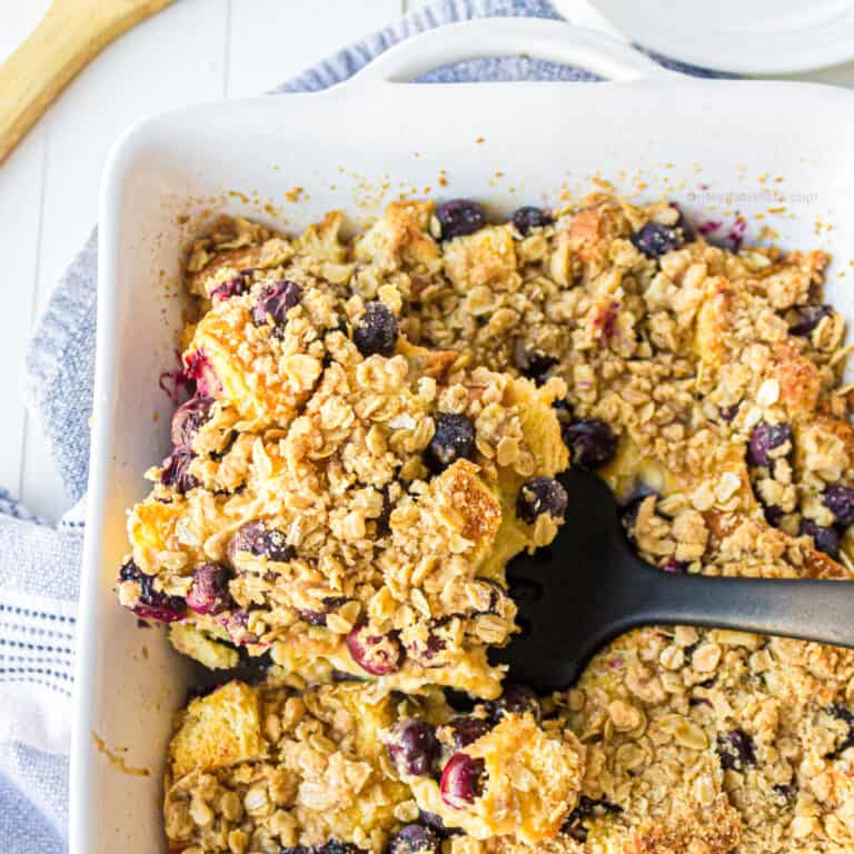 Pan of blueberry french toast casserole from overhead being scooped out of the pan.